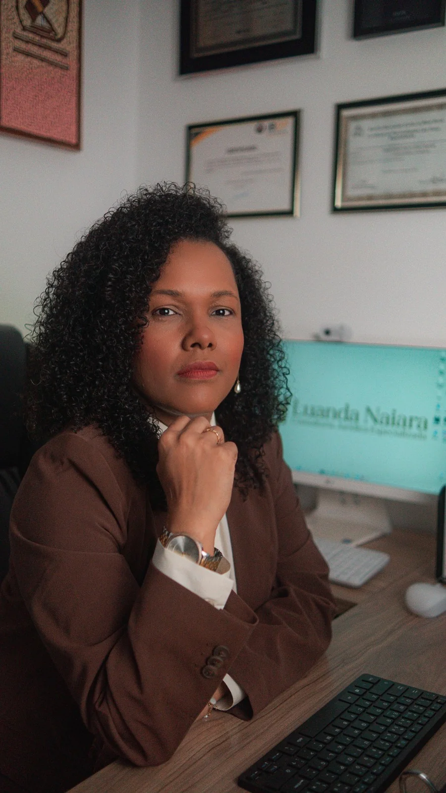 Dra Luanda Naiara pensativa na mesa de trabalho